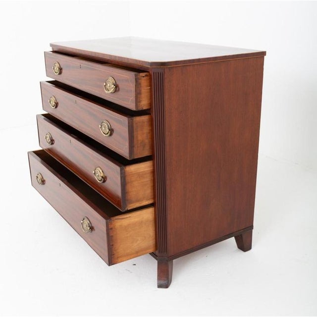 A fine Regency mahogany four-drawer chest of elegant and restrained design The chest stands upon splayed feet and features...
