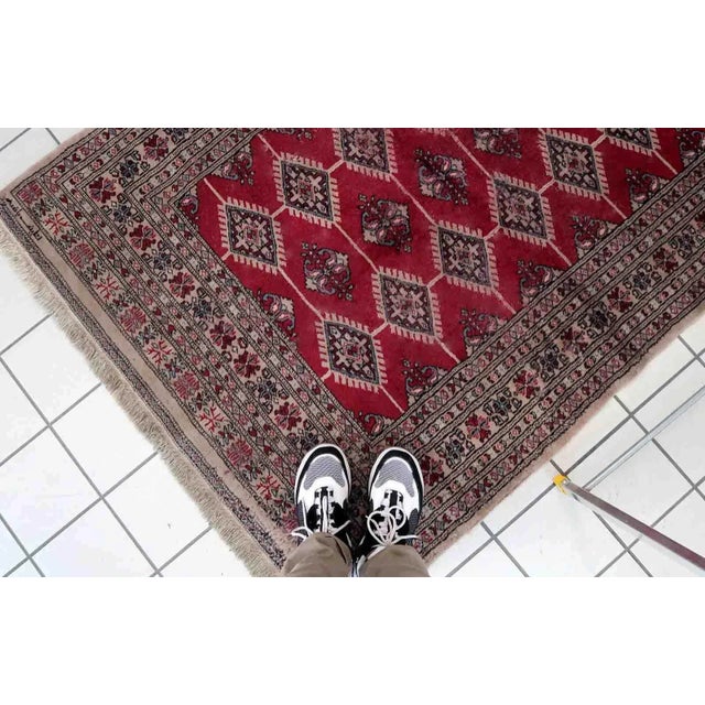 Handmade vintage Uzbek Bukhara rug in red color. The rug has been made in wool in the end of 20th century. It is in...