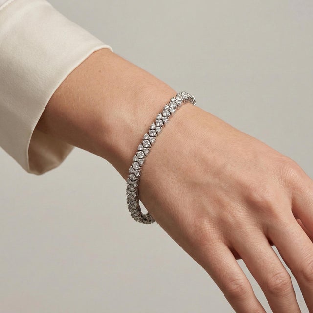 Modern 3 dimensional tennis bracelet crafted in heavy 18k white gold. Featuring approximately 5.3 carats of mixed-cut...