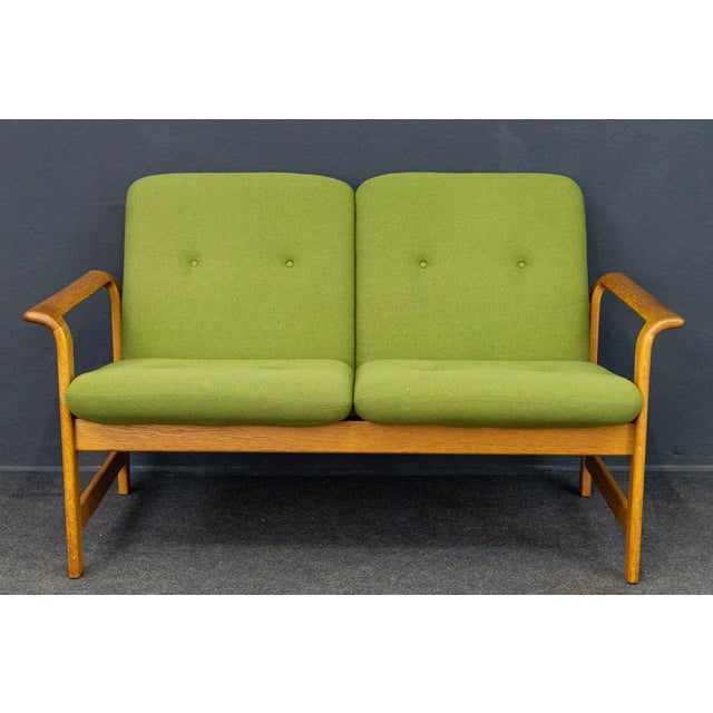 Object: 2-seater sofa Epoch & style: 70s/80s Features: - Sofa and armchair construction made of solid oak - Seat cushions...