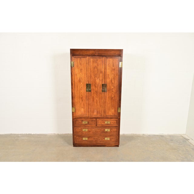 A gorgeous Mid-Century Modern Campaign style armoire dresser or gentleman's chest By Henredon USA, Circa 1970s Oak, with...