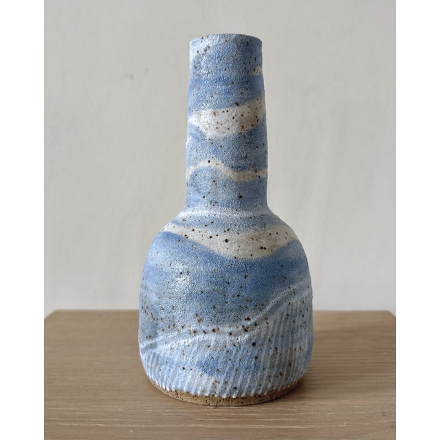 A slender American studio pottery bottle vase made in New York, finished in soft powder-blue and cream glazes over a...
