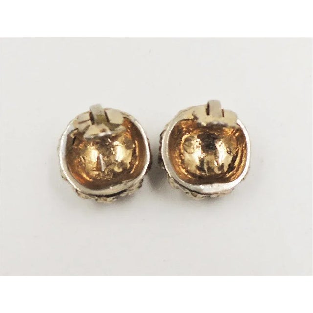 This is part of Chairish’s Costume Jewelry assortment. 1950s round goldtone leaves with pave clear rhinestone clip back...