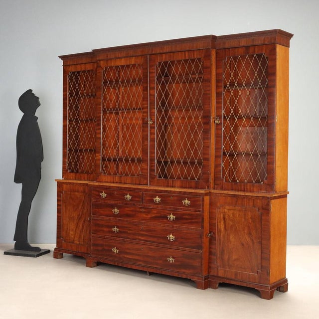 Early 20th-century mahogany bookcase from England, featuring distinctive ebony and walnut inlays. The upper section is...