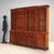 Early 20th-century mahogany bookcase from England, featuring distinctive ebony and walnut inlays. The upper section is...