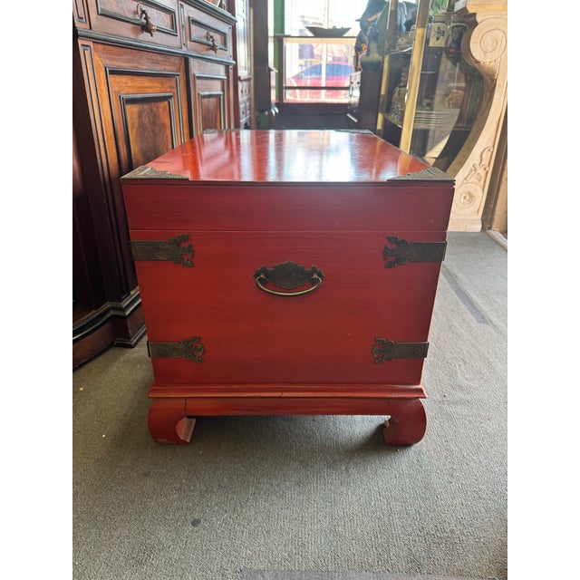 A striking vintage Chinese red lacquer chest, hand-crafted with traditional brass mounts and curved horse-hoof feet. The...