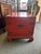 A striking vintage Chinese red lacquer chest, hand-crafted with traditional brass mounts and curved horse-hoof feet. The...