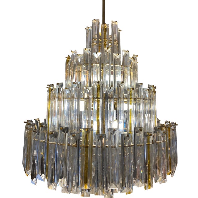 Four-tier chandelier from the 1970s, made by Paolo Venini. Composed of unique pieces of clear and gold-plated glass with a...