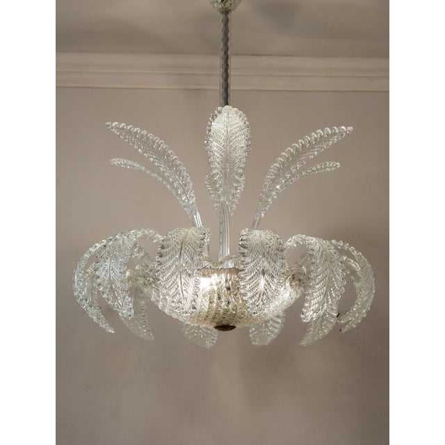 Venetian chandelier from the 1930s, crafted in the Ercole Barovier furnaces, with a distinctive floral structure in clear...