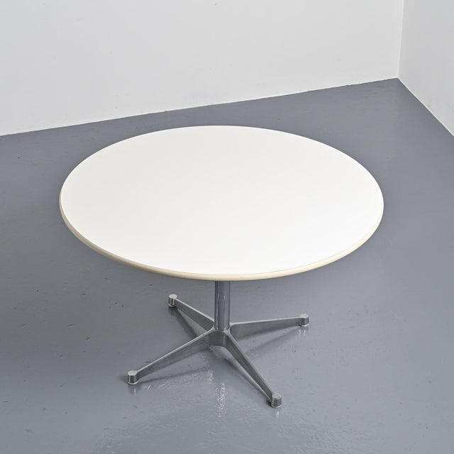 Round table designed by Charles and Ray Eames for Herman Miller, circa 1970. It consists of a circular white tabletop...