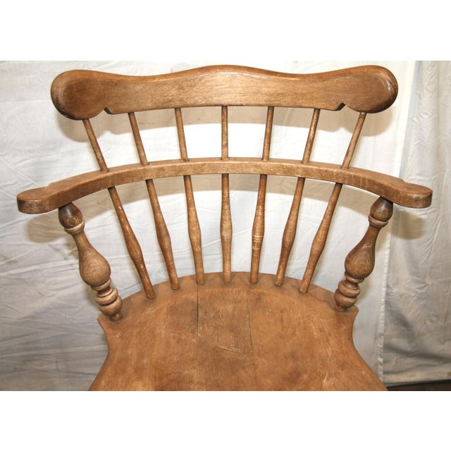 Vintage captain’s swivel barstool with a spindle high back and metal footrest. Turned spindle legs and armrest supports...