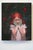 In "Girl with Peppers," a young girl with flowing red hair stands amidst a dark, leafy background, her hands gently...
