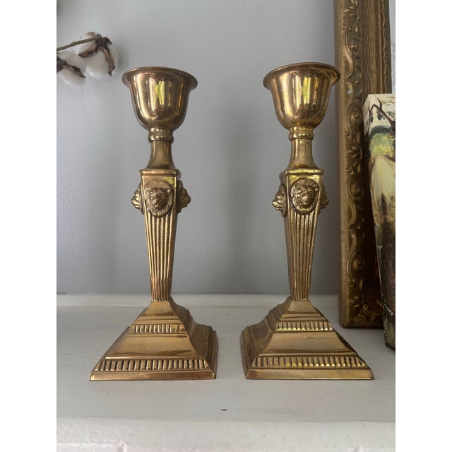 2 Elegant brass candlesticks with a polished gold finish. This pair has a square base tiered base with fluted stem. There...