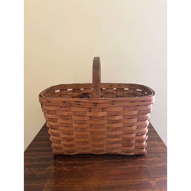 A beautifully woven early 20th century American splint oak basket with warm honeyed tones and a tightly constructed...