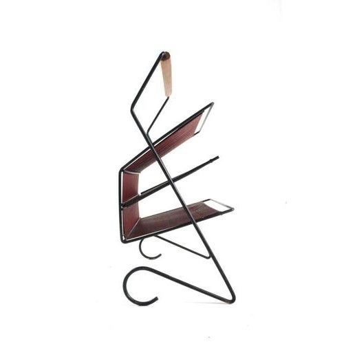 A magazine holder in lovely vintage condition, consisting of black lacquered metal, a wooden handle, and "compartments"...