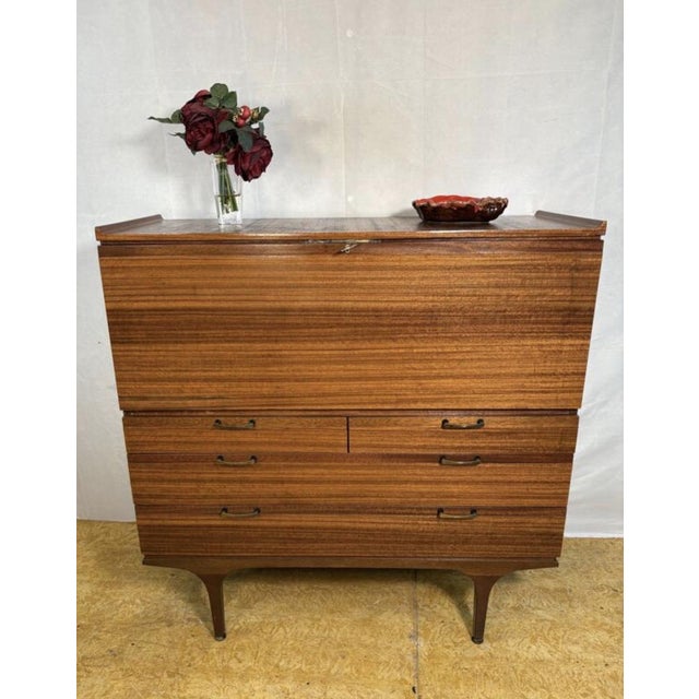 A beautifully designed mid-century teak bureau by meredew, dating from the 1960s, combining practicality with the clean,...