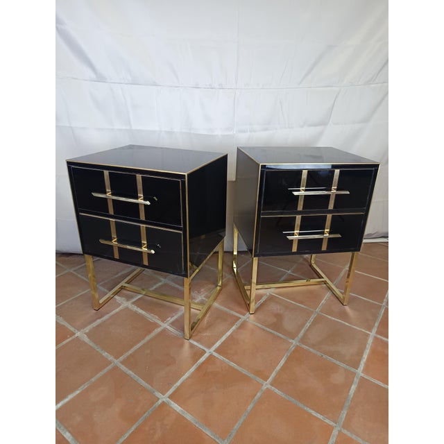 The nightstand, with its black glass surface, exudes a sense of freshness and elegance. Refined brass details extend along...