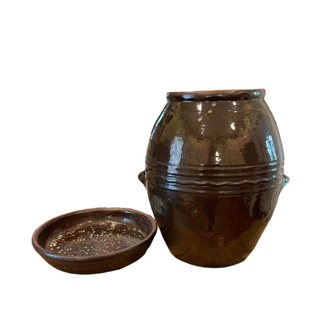 A vintage, hand made red ware jar/crock. Features a brown glaze over a hand firmed red ware pottery vessel. Complete with...