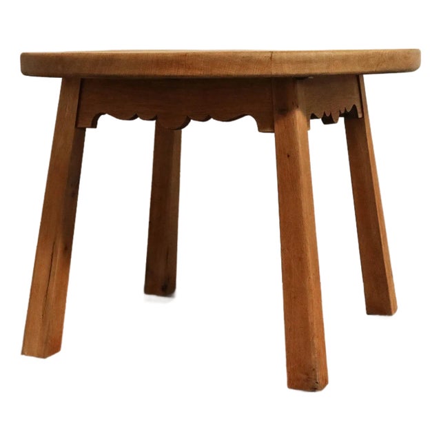 A brutalist Danish oak side table showcasing a scalloped apron detail and simple tapered legs.