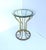 A brass‑plated hourglass‑form side table with glass top, in the style of Modern and Postmodern design styles, circa...