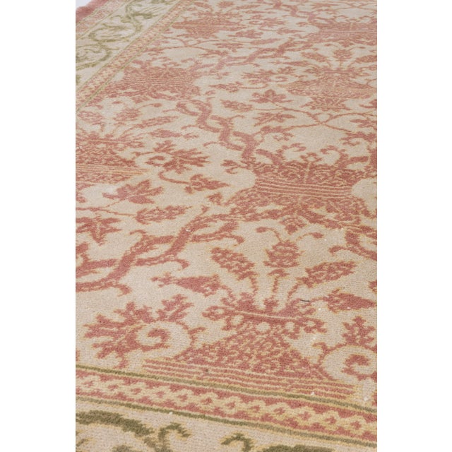 A mid 20th century Spanish style rug, the pale ivory/beige field with an overall pattern in light brick of restrained...