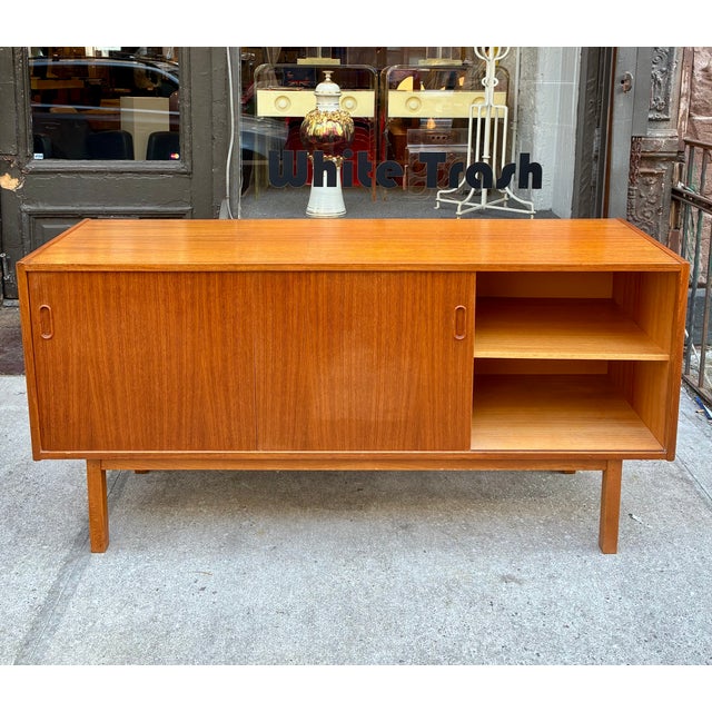 Teak Credenza from Sweden made in the early 1970s. The two side compartments have an adjustable shelf and the exposed...