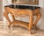 An elegant French Provincial-style console table showcasing an ornate, sculptural silhouette inspired by classic Louis XV...