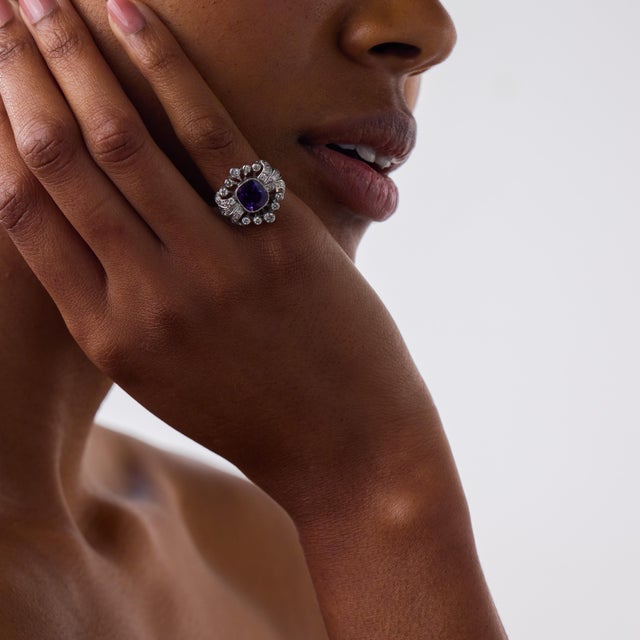 This elegant Mid Century cocktail ring is a striking 1950’s design, centered by a cushion brilliant cut amethyst weighing...