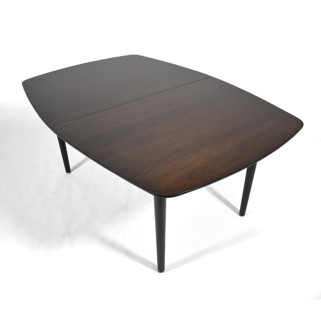 This beautifully detailed walnut dining table designed in 1951 by Finn Juhl for Baker Furniture has several of Juhl's...