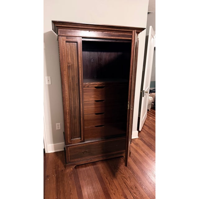 This is an Antique Art Nouveau oak wardrobe featuring a single mirrored door and a drawer. The design embodies the...
