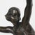 An Art Deco, patinated bronze dancer in stylised pose, holding two vine leaves aloft. Set over a bi-coloured marble...