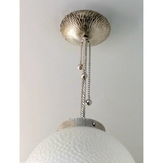 A French Art Deco wrought iron ball pendant chandelier. The fixture was re plated in nickel and re wired to U.S. standards...