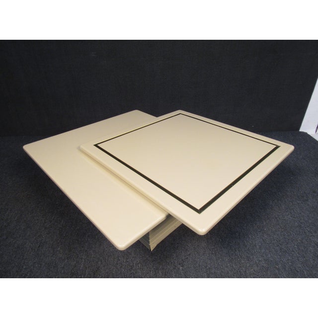 Rare and unique two-tier coffee table by Rougier in ivory lacquered wood. Two Diamond shaped leaves pivot around a central...