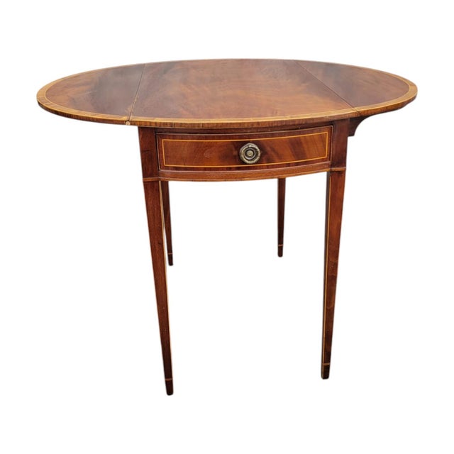 This elegant 1940s American Pembroke table is made from solid crushed mahogany and features a finely banded inlay top....