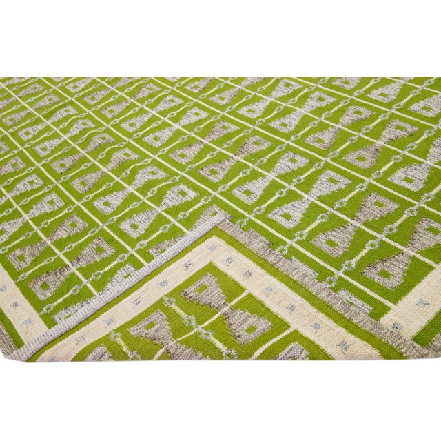 Beautiful modern Swedish-style wool rug with a green field. This piece has gray and beige accent colors featuring a...