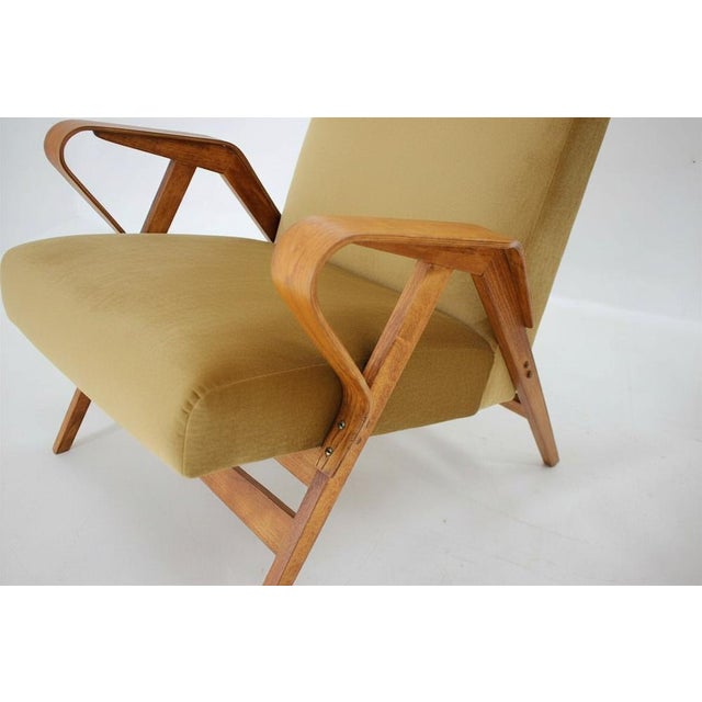 A well-balanced pair of mid century armchairs with distinctive angular armrests and clean structural lines. The design...