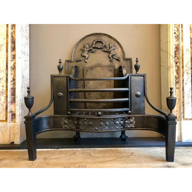 An unusual English 19th century large fire grate. The pierced guilloche fret with cut steel buttons, surmounted by shaped...