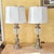 A matching pair of tall table lamps featuring polished chrome bases with crackle glass globe accents and crisp white...