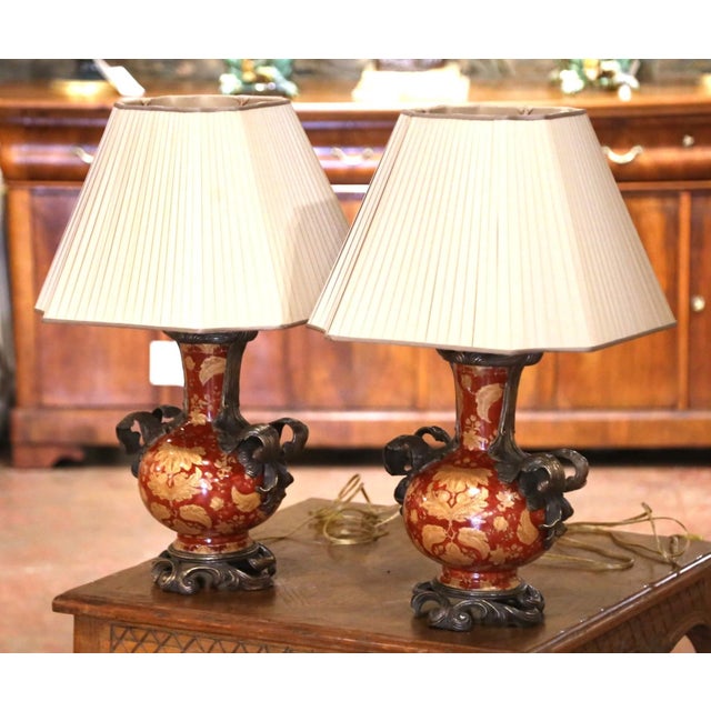 This striking pair of vintage table lamps combines richly decorated Chinese Export-style porcelain with sculptural bronze...