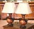 This striking pair of vintage table lamps combines richly decorated Chinese Export-style porcelain with sculptural bronze...