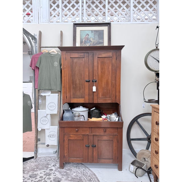 Built from solid pine, the hutch rises in a tall, balanced silhouette: two upper doors, two drawers, and two lower doors...