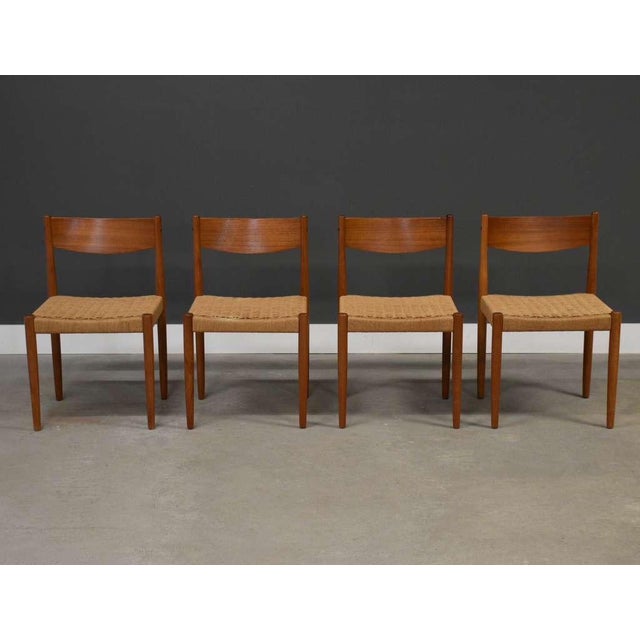 A set of four mid century modern teak frame dining chairs with paper cord seats by Poul Volther for Frem Røjle. Seat...