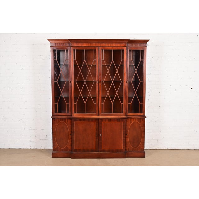 A gorgeous Georgian or Chippendale style lighted breakfront bookcase cabinet or dining cabinet By Baker Furniture,...