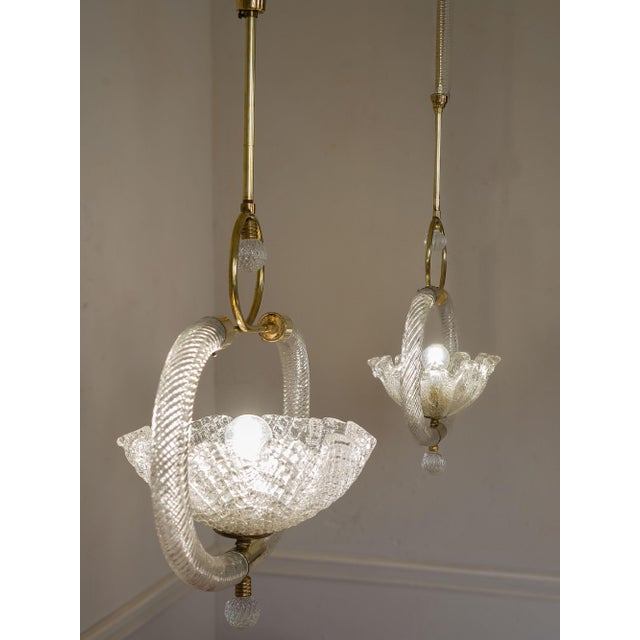 A pair of murano glass and brass chandeliers, made in the 1940s and attributed to the venetian manufacturer barovier &...