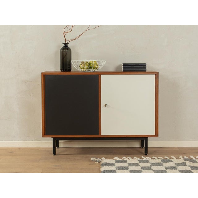 Wonderful chest of drawers from the 1960s. Body in teak veneer with two Formica-coated doors in black and cream white, a...