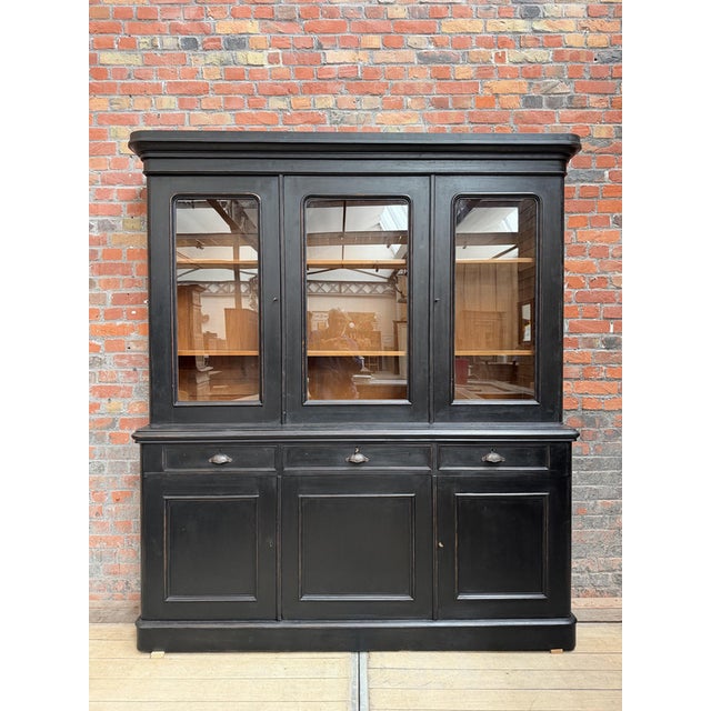 This antique bookcase has been fully restored. It consists of an upper section with three lockable glass doors that open...