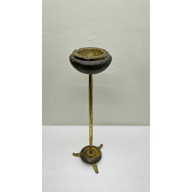 Antique style brass mid-century standing ashtray with tripod base. The ashtray is all brass, the top has a kind of marble...