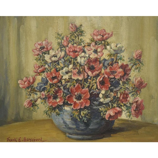 This vibrant still life by Frank Beresford features a lush bouquet of flowers arranged in a rounded blue vessel, set...