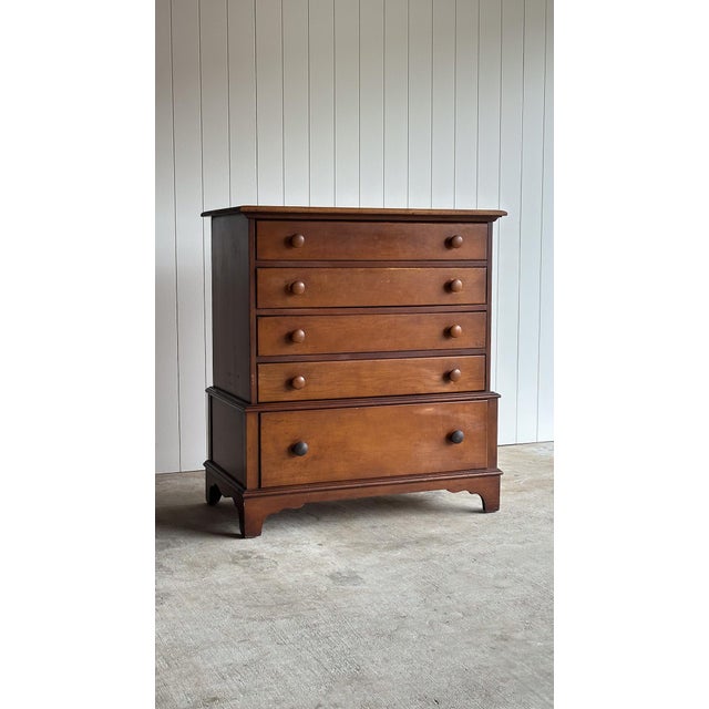 This vintage five-drawer dresser features a clean transitional silhouette with softly rounded edges, paneled sides, and...