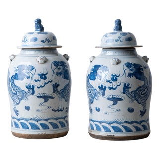 Pair of Chinese Blue and White Glazed Dragon Jars With Foo Dog Lid Finials For Sale